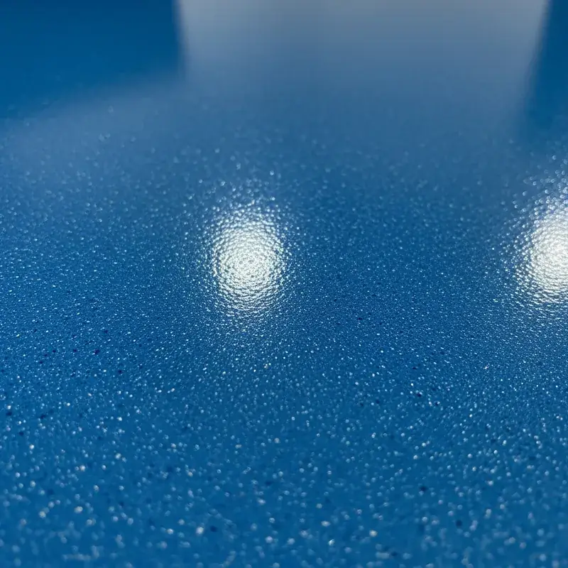 Nahaufnahme einer blauen Bodenbeschichtung mit Farbchip-Einstreuung