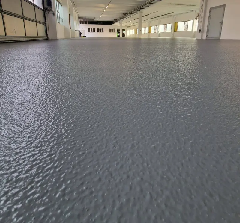 Graue Industrieboden-Beschichtung in Produktionshalle – robuste Epoxidharz Bodenbeschichtung
